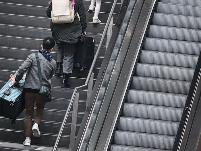 Fahrgäste tragen ihre Koffer am Berliner Hauptbahnhof über die Treppe. (Archivbild) / Foto: Britta Pedersen/dpa