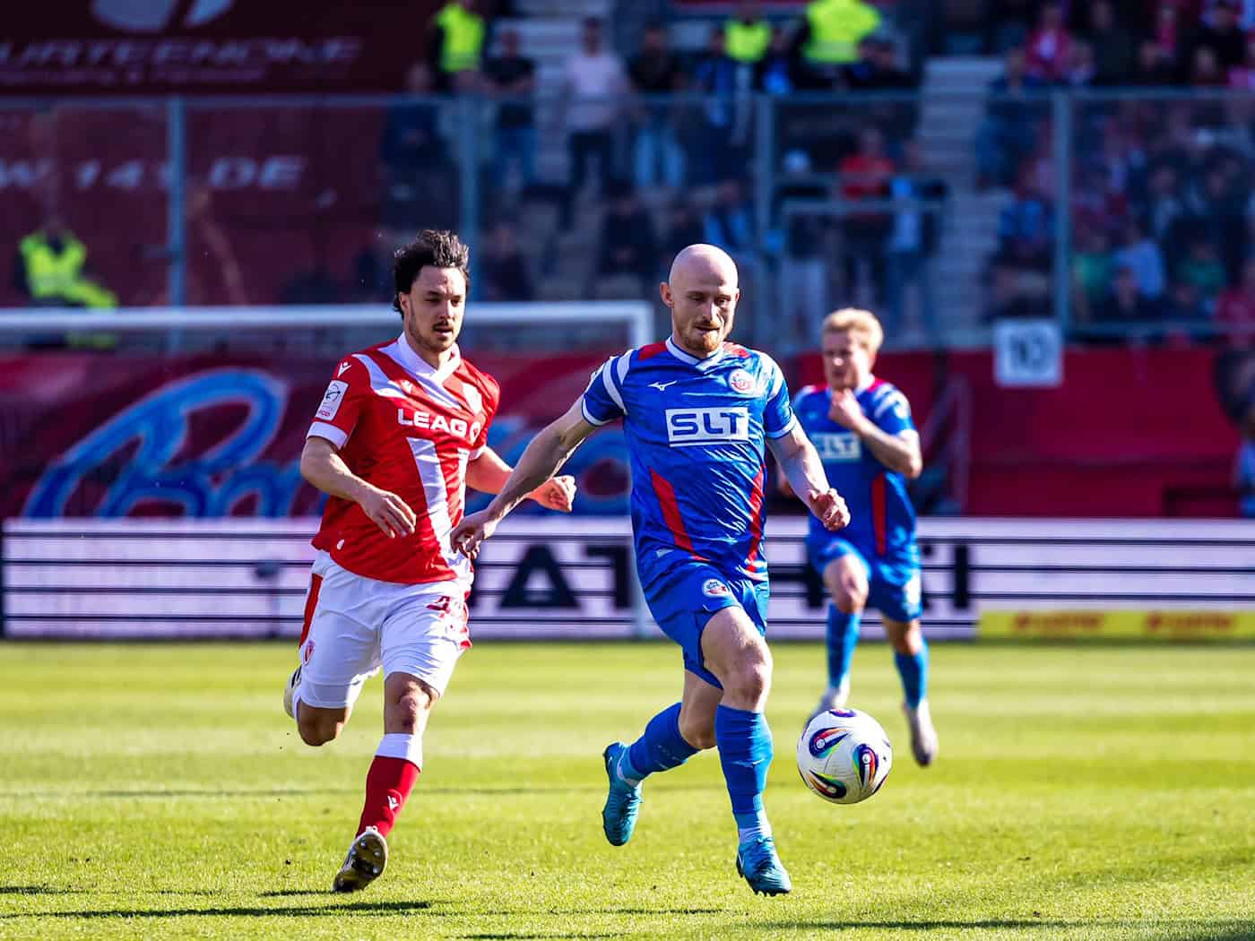 Simon Straudi (FC Energie Cottbus, l) unnd Maximilian Krauß (Hansa Rostock) kämpfen um den Ball. / Foto: Frank Hammerschmidt/dpa