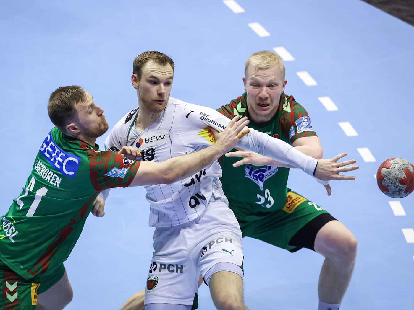 Die Magdeburger Albin Lagergren (l.) und Magnus Saugstrup attackieren Berlins Welthandballer Mathias Gidsel. / Foto: Ronny Hartmann/dpa-Zentralbild/dpa