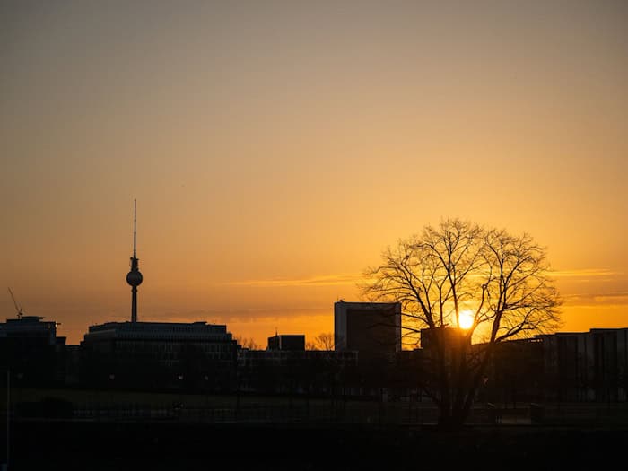 Die Sonne geht am Himmel über Berlin auf. Nur wenige Wolken sind zu sehen. (Symbolbild) / Foto: Christophe Gateau/dpa