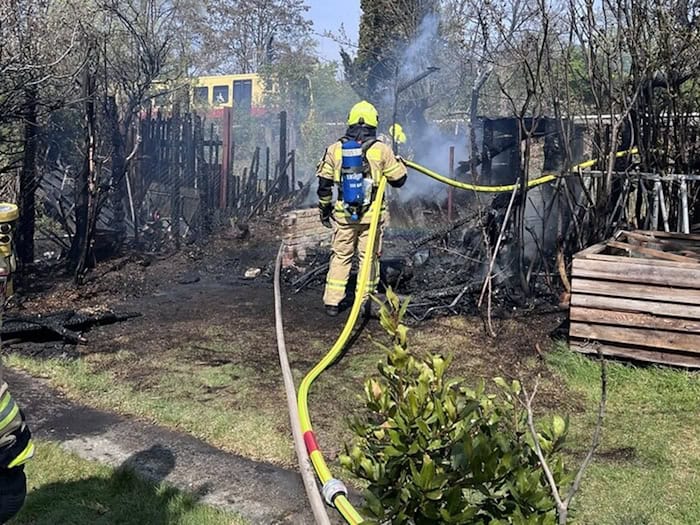 Einsatzkräfte der Feuerwehr löschen den Brand zweier Gartenhäuser. (Handout)  / Foto: ---/Berliner Feuerwehr/dpa