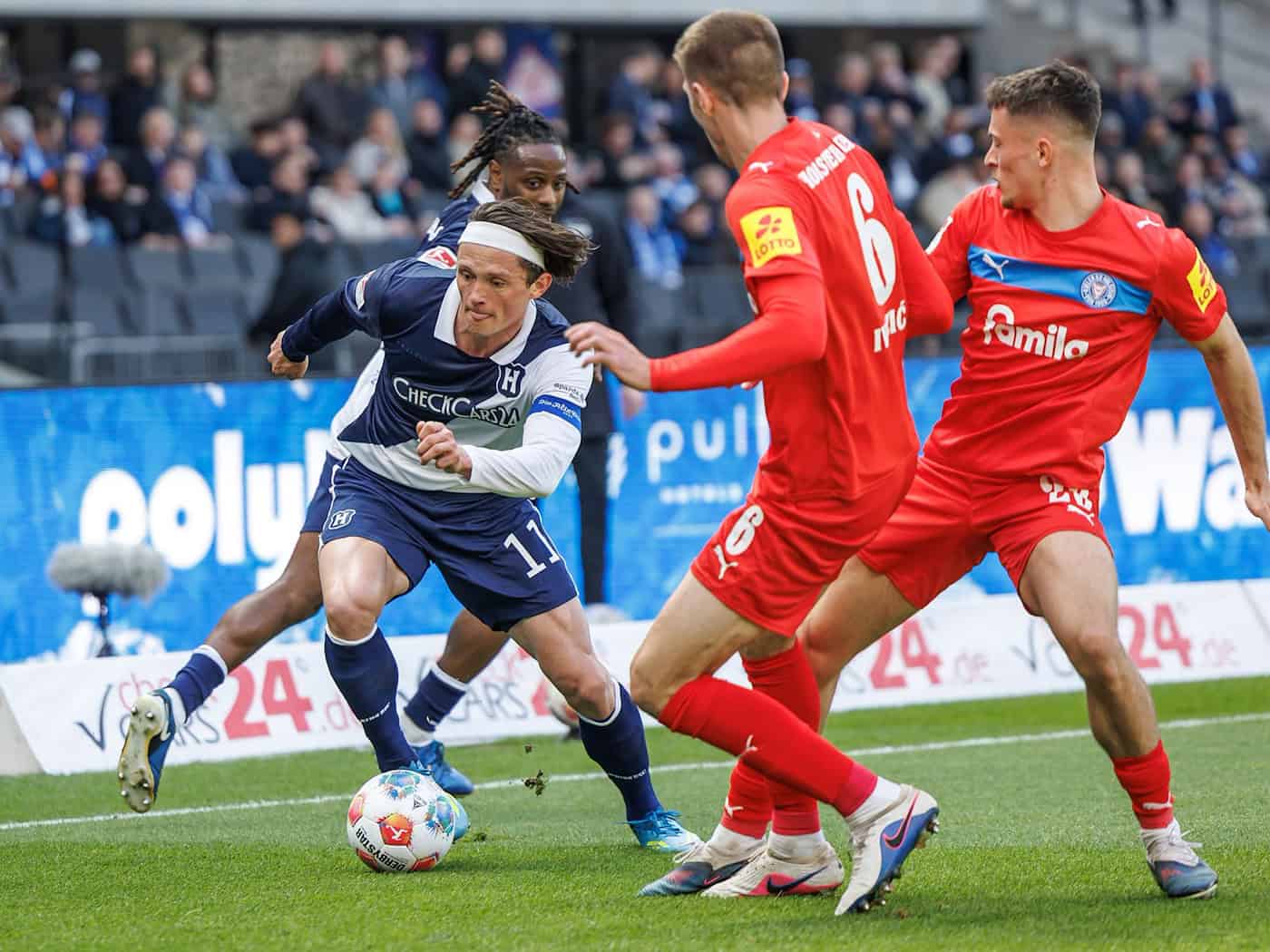 Herthas Fabian Reese (l.) zieht an zwei Kieler Gegenspielern vorbei.  / Foto: Andreas Gora/dpa