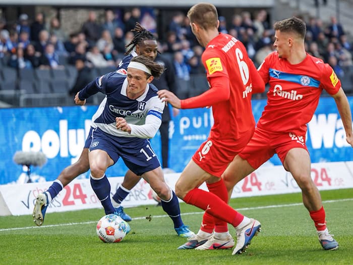 Herthas Fabian Reese (l.) zieht an zwei Kieler Gegenspielern vorbei.  / Foto: Andreas Gora/dpa