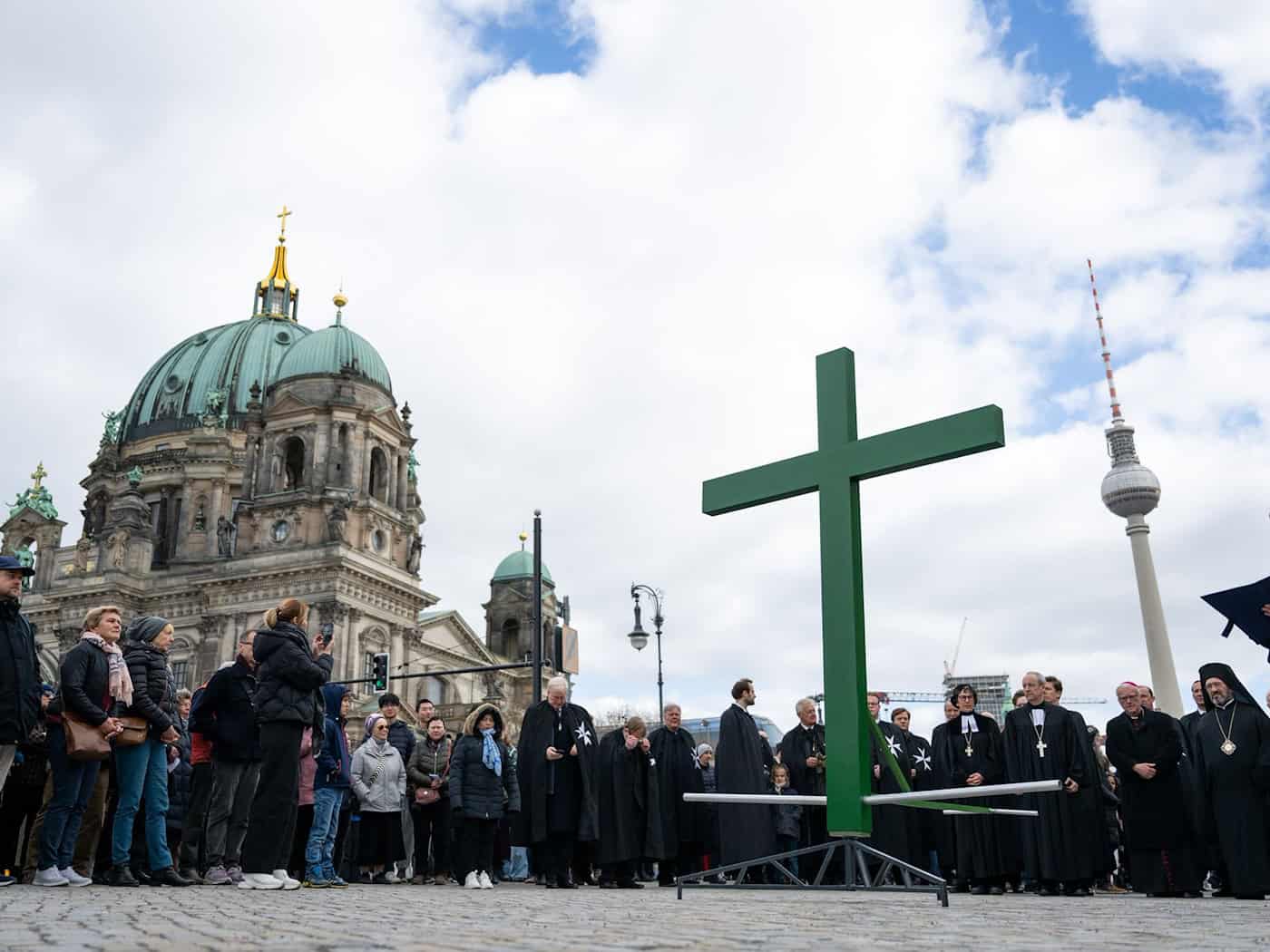 Bei der Karfreitagsprozession wurde auch dieses Jahr wieder ein goßes grünes Kreuz durch die Innenstadt getragen. / Foto: Christophe Gateau/dpa