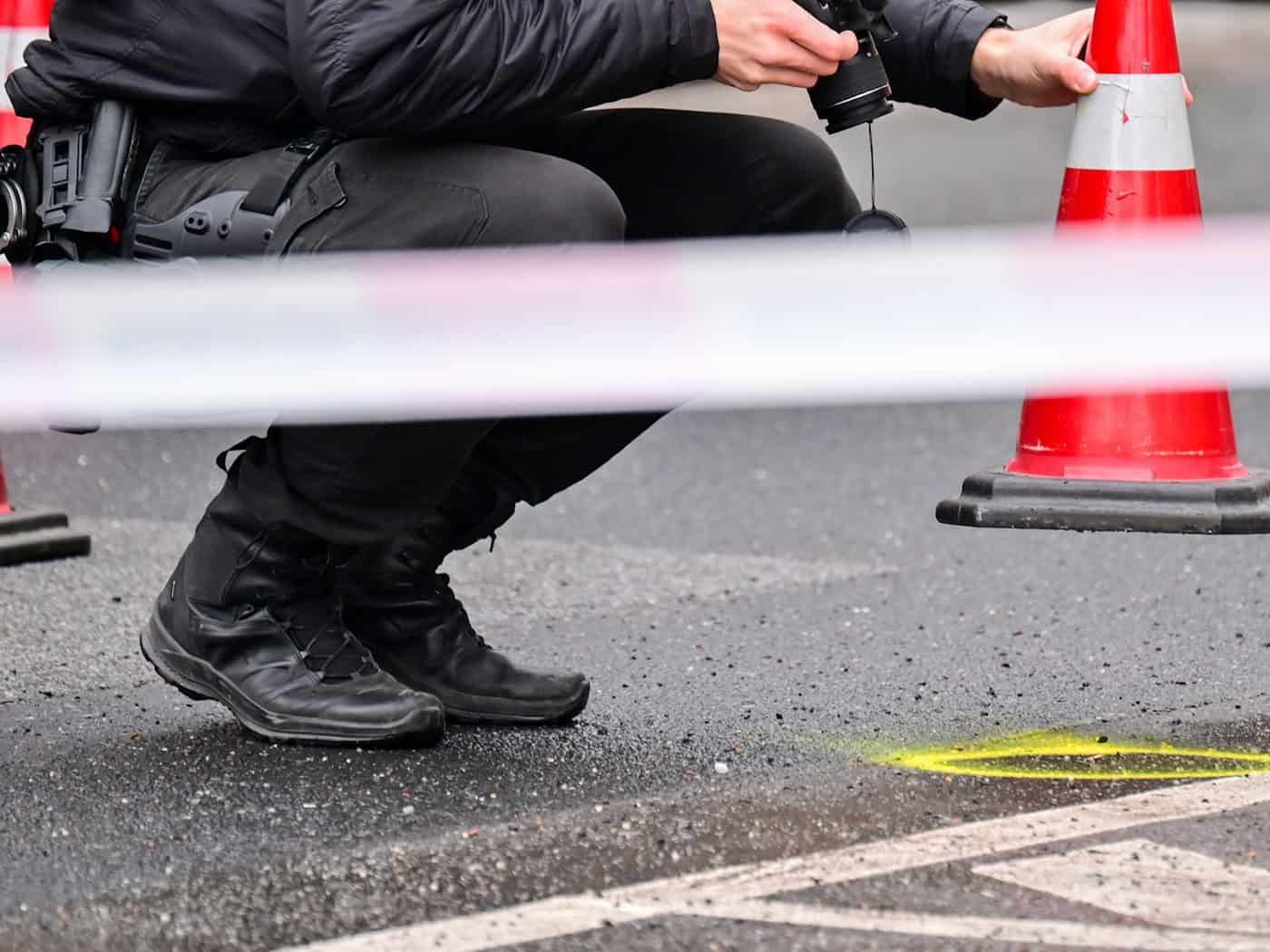 Ein Polizeibeamter fotografiert ein Beweismittel auf der Straße. (Archivbild)  / Foto: Sebastian Gollnow/dpa