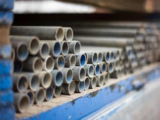 Stapel aus hochwertigen Edelstahlrohren in einem Industrie- oder Baustofflager, bereit für den Einsatz in Maschinenbau, Architektur oder nachhaltigen Projekten.