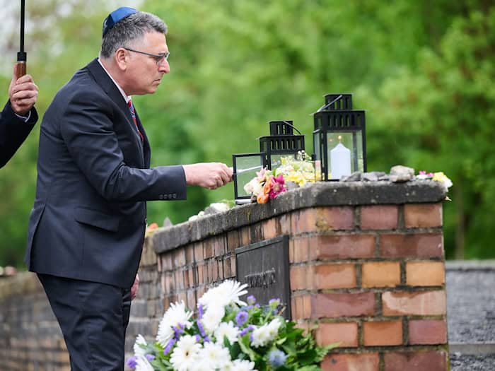 Israels Außenminister Gideon Saar zündet bei seinem Besuch am Mahnmal "Gleis 17" eine Kerze an. / Foto: Annette Riedl/dpa
