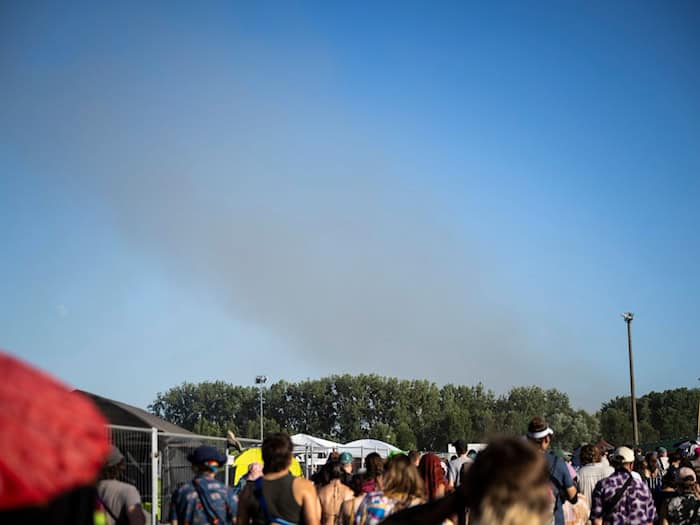 Eine Rauchsäule steigt unweit des Festivalgeländes in die Luft.  / Foto: Philip Dulian/dpa