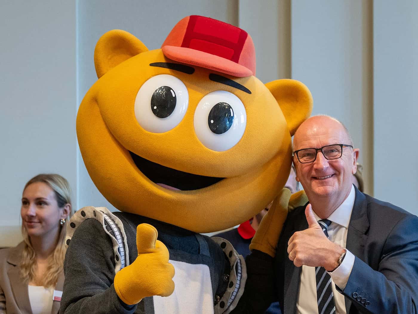 Das Filmpark-Maskottchen «Flimmy» bringt Brandenburgs Ministerpräsidenten Dietmar Woidke beim Kindertagsfest in der Staatskanzlei zum Lachen.  / Foto: Soeren Stache/dpa