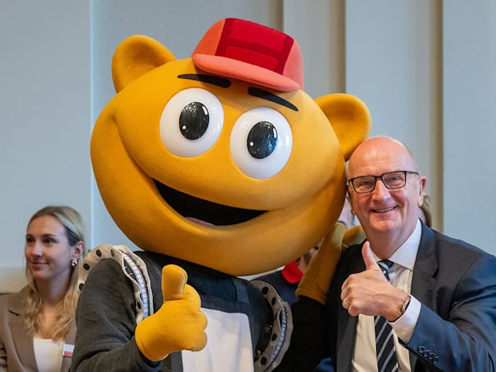 Das Filmpark-Maskottchen «Flimmy» bringt Brandenburgs Ministerpräsidenten Dietmar Woidke beim Kindertagsfest in der Staatskanzlei zum Lachen.  / Foto: Soeren Stache/dpa
