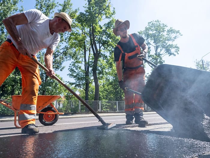 Für sie war es Schwerstarbeit - Asphaltarbeiten bei großer Hitze. (Archivbild) / Foto: Georg Moritz/dpa