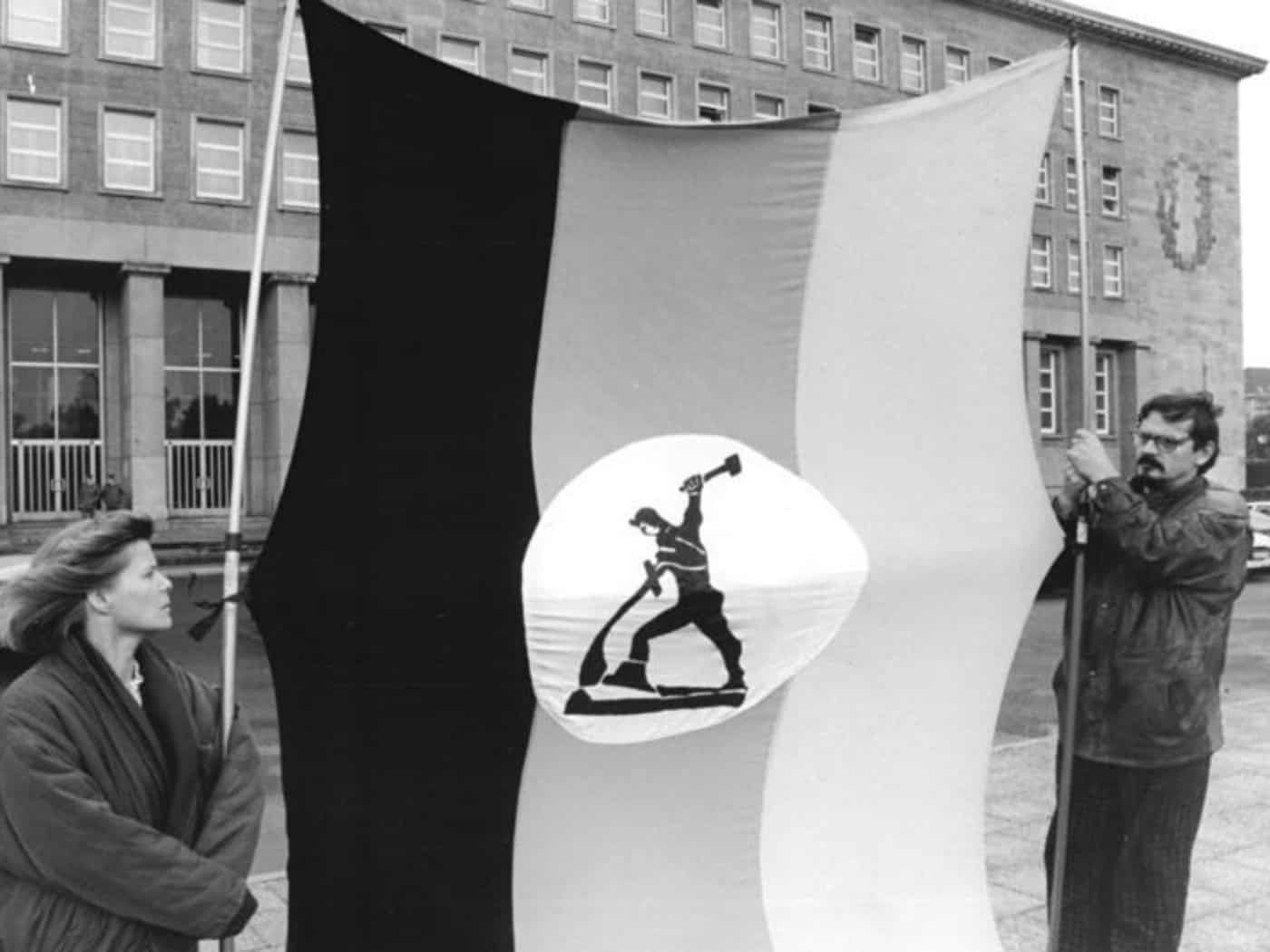 Schwerter zu Flugscharen: Zwei brandenburger Christen aus Neustadt an der Dosse protestieren 1990 vor der Volkskammertagung zum Einigungsvertrag. © Bundesarchiv, Bild 183-1990-0926-026 / Grimm, Peer / CC BY-SA 3.0 DE via Wikimedia Commons.