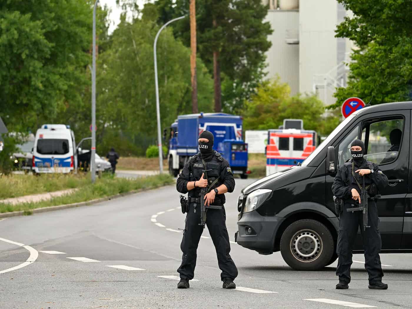 Schwer bewaffnete Polizisten sperren den Zugang zu einer Halle in Ludwigsfelde ab, wo es Durchsuchungen gibt. / Foto: Soeren Stache/dpa