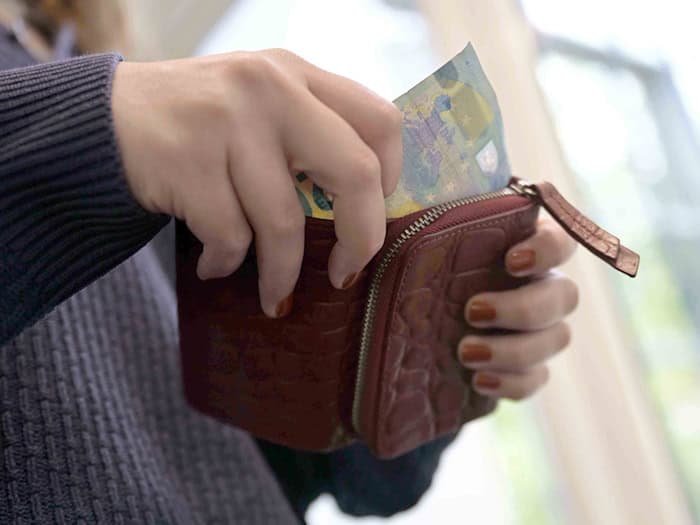 Eine Frau nimmt einen 20-Euro-Schein aus ihrem Portemonnaie. (Symbolbild)  / Foto: Malin Wunderlich/dpa