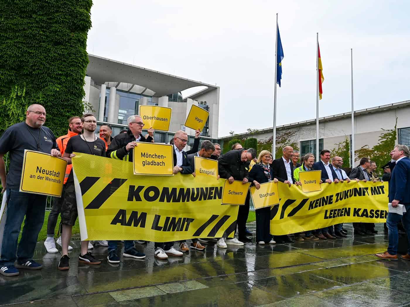 Vertreter mehrerer Städte und Kommunen demonstrieren mit Schildern und Bannern für finanzielle Unterstützung in Berlin. / Foto: Jens Kalaene/dpa