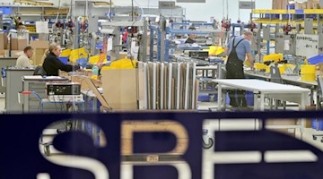 Mitarbeiter der SBF Spezialleuchten GmbH arbeiten im Werk in Leipzig. Foto: Jan Woitas/dpa-Zentralbild/dpa/Archivbild