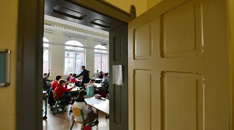 Schülerinnen und Schüler sitzen in einem Klassenzimmer. Foto: Martin Schutt/zb/dpa/Archivbild