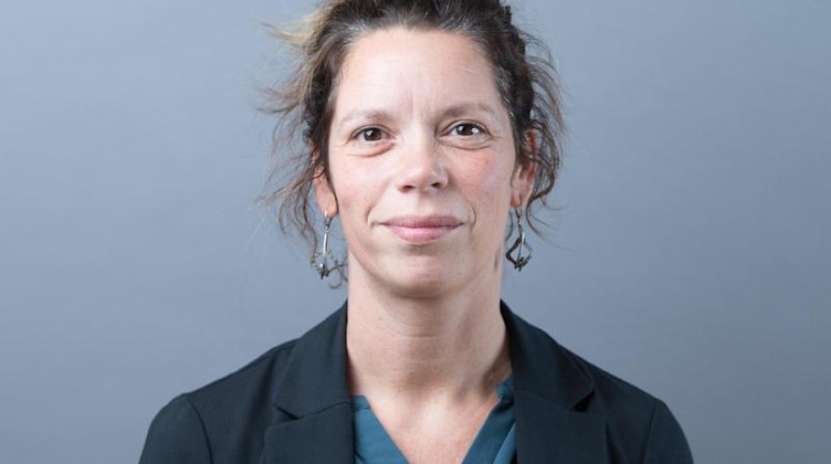 Antje Feiks (Die Linke) steht anlässlich der konstituierenden Sitzung des sächsischen Landtags vor einer Fotowand. Foto: Sebastian Kahnert/zb/dpa/Archivbild