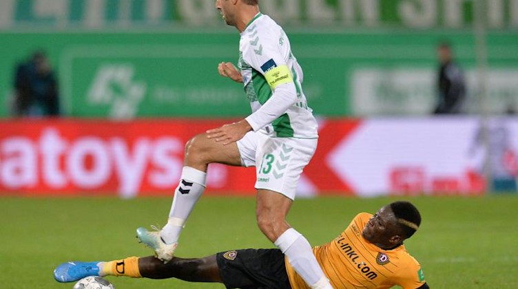 Marco Caligiuri (l.) von Fürth spielt gegen Moussa Kone von Dresden. Foto: Timm Schamberger/dpa