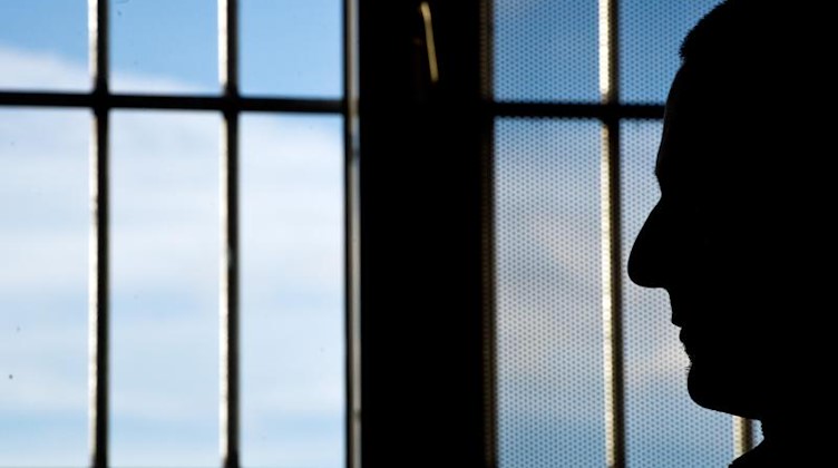 Ein Gefängnisinsasse sitzt in einer Justizvollzugsanstalt vor einem Fenster. Foto: Daniel Naupold/dpa