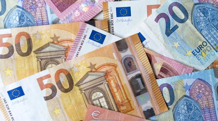 Verschiedene Banknoten liegen auf einem Haufen. Foto: Monika Skolimowska/zb/dpa/Archivbild