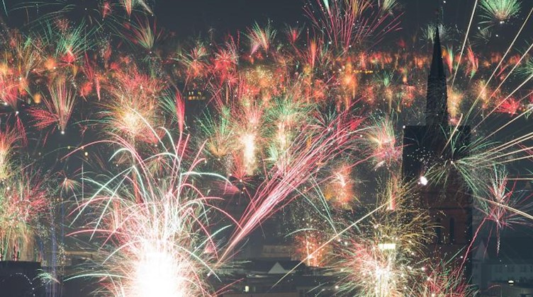 Feuerwerk explodiert kurz nach Mitternacht am Nachthimmel. Foto: Julian Stratenschulte/dpa/Archivbild