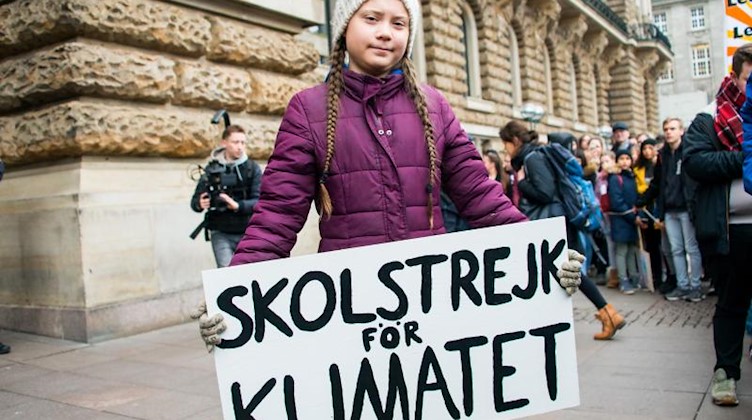 Greta Thunberg steht mit einem Transparent auf einer Demonstation vor einem Rathaus. Foto: Daniel Bockwoldt/dpa/Archiv