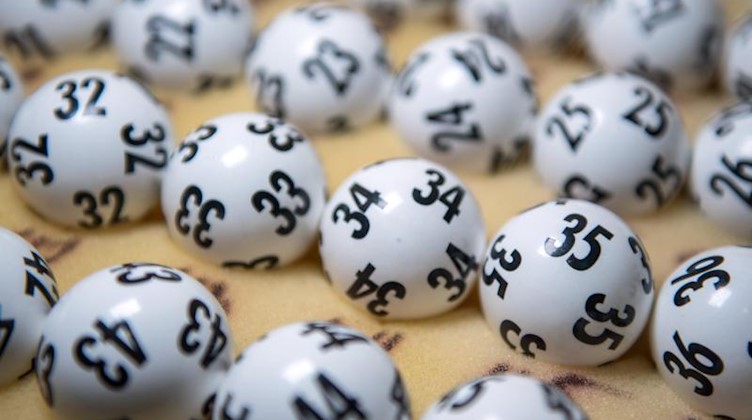 Lottozahlen liegen auf einem Tisch. Foto: Hendrik Schmidt/zb/dpa/Archivbild