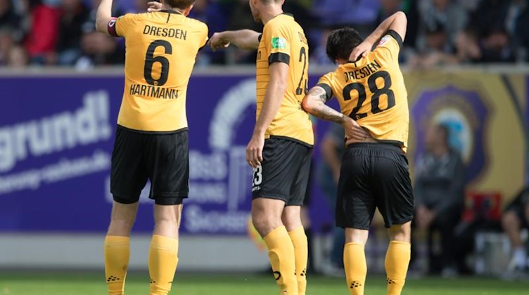 Dynamos Marco Hartmann (l-r), Florian Ballas und Baris Atik stehen während des Spiels nebeneinander. Foto: Sebastian Kahnert/dpa-Zentrabild/dpa/Archivbild