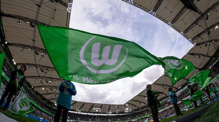Fahnen werden von den Fans für den VfL Wolfsburg geschwenkt. Foto: Peter Steffen/dpa