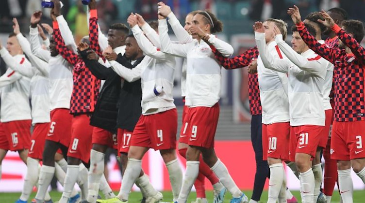 Die Mannschaft von RB Leipzig jubelt über den 2:1 Sieg gegen St. Petersburg vor der Fankurve. Foto: Jan Woitas/dpa-Zentralbild/dpa/Archivbild