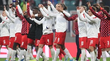 Die Mannschaft von RB Leipzig jubelt über den 2:1 Sieg gegen St. Petersburg vor der Fankurve. Foto: Jan Woitas/dpa-Zentralbild/dpa/Archivbild