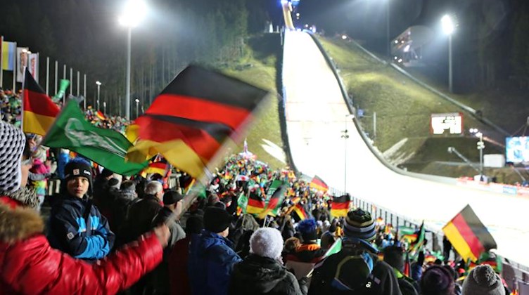 Fans jubeln beim Skispringen von der Großschanze in der Vogtland-Arena in Klingenthal. Foto: Jan Woitas/dpa-Zentralbild/dpa/Archivbild