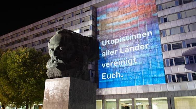 Lichtinstallation mit der Aufschrift «Utopistinnen aller Länder vereinigt euch» in Chemnitz. Foto: Sebastian Kahnert/dpa-Zentralbild/dpa