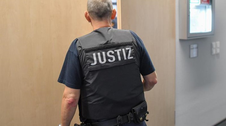Ein Justiz-Beamter steht in einem Flur des Amtsgericht Cottbus. Foto: Patrick Pleul/dpa-Zentralbild/dpa