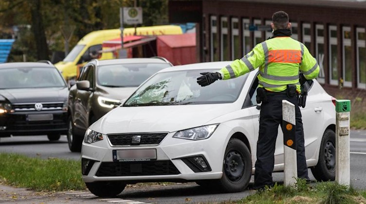 Polizisten der Bundespolizei kontrollieren an der Grenze zu Belgien eine Autofahrerin. Foto: Ralf Roeger/dpa