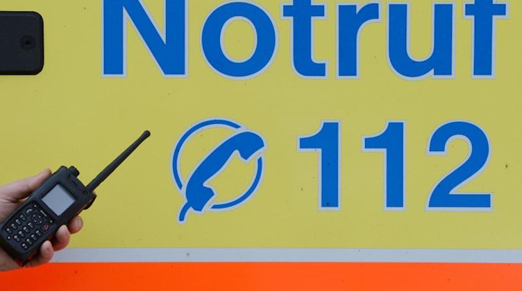 Ein Sanitäter vor einem Rettungswagen mit der Nummer des Notrufes. Foto: Jens Kalaene/dpa-Zentralbild/dpa/Symbolbild
