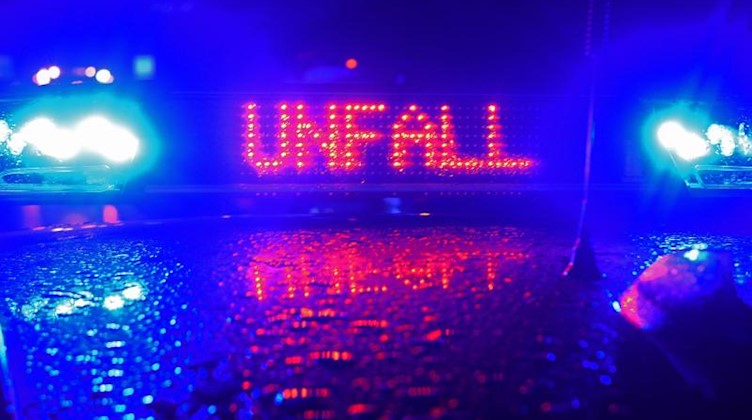 Ein Blaulicht und der LED-Schriftzug «Unfall» auf dem nassen Dach eines Polizestreifenwagens. Foto: Stefan Puchner/dpa/Symbolbild
