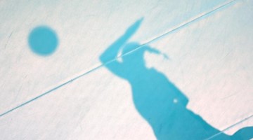 Der Schatten einer aufschlagenden Spielerin ist auf dem Hallenboden zu sehen. Foto: Friso Gentsch/dpa/Archivbild