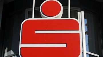 Das Logo der Sparkasse hängt an einer Hausfassade. Foto: Jens Kalaene/dpa-Zentralbild/dpa/Archivbild