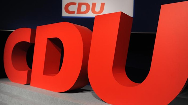Das Logo der CDU steht in roten Buchstaben vor einer schwarzen Wand. Foto: Arno Burgi/zb/dpa/Archivbild
