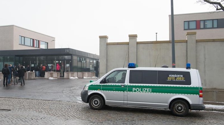 Ein Polizeifahrzeug und Journalisten stehen vor der Justizvollzugsanstalt (JVA) Dresden. Foto: Sebastian Kahnert/zb/dpa/Archivbild