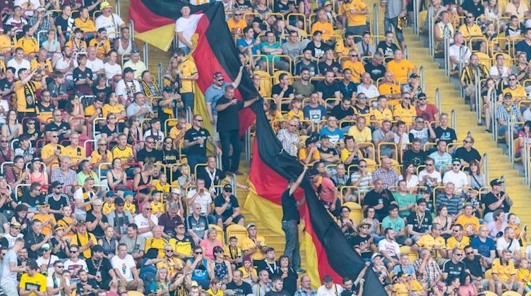 Dresdner Fans halten Deutschland-Fahnen hoch. Foto: Robert Michael/zb/dpa/Archivbild