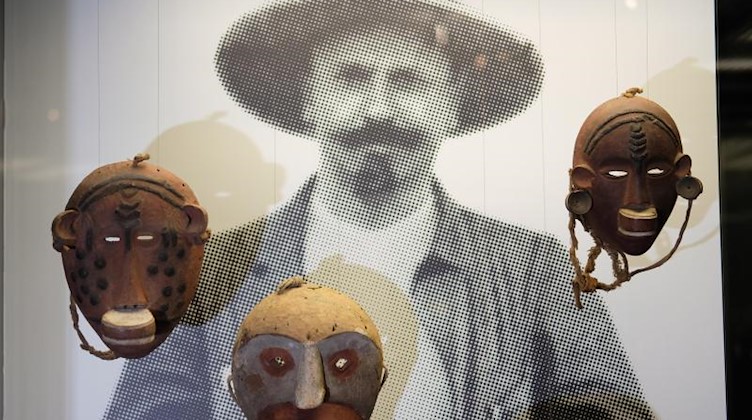 Ein Bild von Karl Woile, früherer Direktor des Leipziger Völkerkundemuseums, sowie Initiationsmasken aus Tansania aus der Zeit um 1908. Foto: Sebastian Willnow/zb/dpa