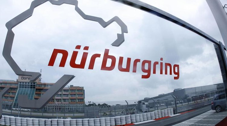Eine Glasscheibe mit dem Logo der Rennstrecke Nürburgring. Foto: Jens Büttner/dpa/Archivbild