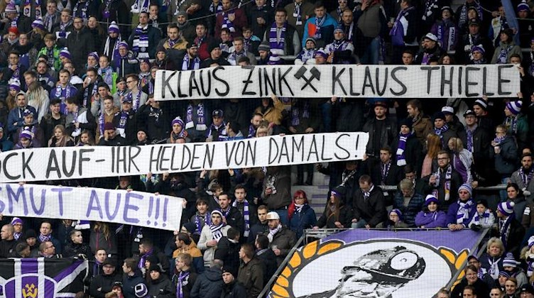 Fans halten Transparente im Stadion: «Klaus Zink Klaus Thiele, Glück auf - ihr Helden von damals!». Foto: Monika Skolimowska/dpa-Zentralbild/dpa/Archivbild