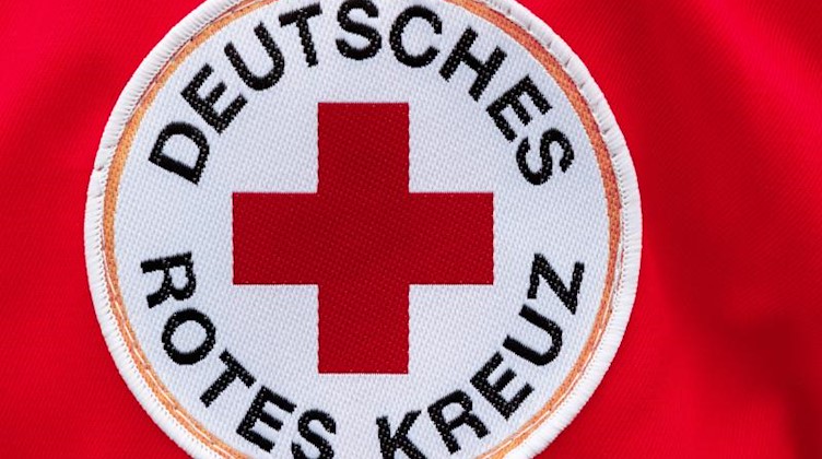 Ein Aufnäher mit dem Logo des Deutschen Roten Kreuzes (DRK) ist auf einer Jacke zu sehen. Foto: Markus Scholz/dpa