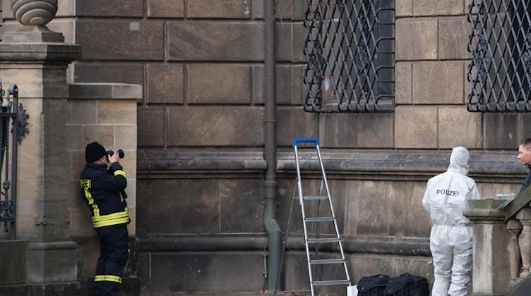 Einsatzkräfte der Polizei am durchtrennten Gitterfenster des Grünen Gewölbes am Residenzschloss. Foto: Sebastian Kahnert/dpa-Zentralbild/dpa