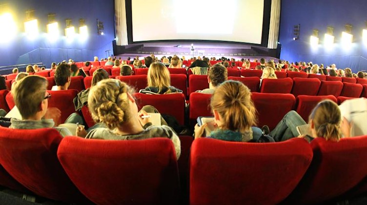Junge Menschen sitzen in einem Kinosaal. Foto: Roland Weihrauch/dpa/Archivbild