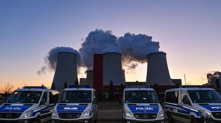 Einsatzfahrzeuge der Polizei stehen am frühen Morgen vor dem Braunkohlekraftwerk Jänschwalde der Lausitzer Energie Bergbau AG (LEAG). Foto: Patrick Pleul/dpa-Zentralbild/dpa